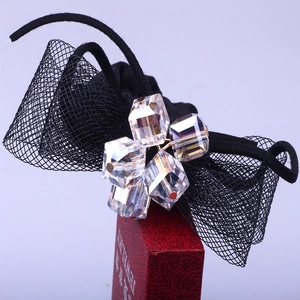 Elegant black lace bow hair tie with sparkling crystal cubes on a jewelry box