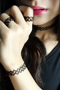 Nahaufnahme von schwarzem Tattoo-Choker, Armband und Ring-Set am Modell