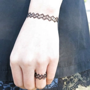 Nahaufnahme des schwarzen elastischen Tattoo-Choker-Armband- und Ring-Sets an der Hand