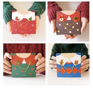 Gros plan sur les broches de Noël émaillées avec double chaîne dorée et motifs festifs