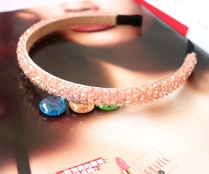 Macro detail of a handmade pink crystal beaded headband on a fashion magazine