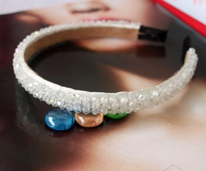 Macro shot of off-white beaded headband with aurora crystal beads and black ear protectors