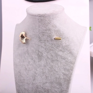 Elegant gold ginkgo leaf brooch with realistic veins on a grey velvet jewelry stand