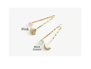 Détail de barrettes coquillage dorées avec strass en lots rose et vert menthe