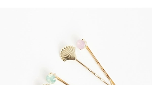 Détail de barrettes coquillage dorées avec strass brillants et pierres colorées