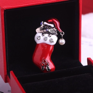 Détail de la broche chat de Noël avec émail rouge, strass et pendentif en perle