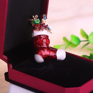 Vue détaillée d'une broche chaussette de Noël en émail avec un casse-noisette sur velours