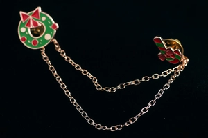 Détail du pin's couronne de Noël festive avec doubles chaînes de connexion dorées