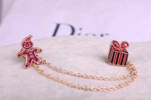 Détail macro de la broche bonhomme de pain d'épices de Noël et boîte cadeau avec chaîne