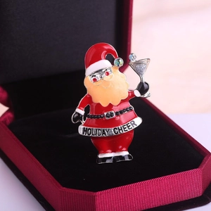 Broche Père Noël avec texte Holiday Cheer et strass sur un coffret cadeau rouge