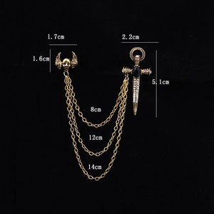 Close-up of gothic skeleton wing badge and sword pin connected by golden triple chains