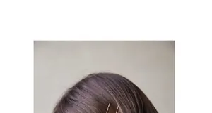Détail de barrettes à cheveux minimalistes en métal doré sur des cheveux foncés