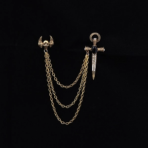 Gothic gold chain brooch with skull wings and rhinestone sword on black background