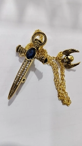 Gothic sword brooch with blue gemstone, wing skull pendant and golden chain detail