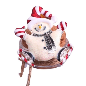 Broche de bonhomme de neige blanc scintillant avec écharpe rouge sur un support en liège
