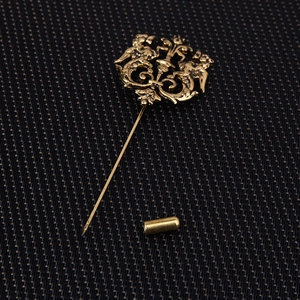 Macro shot of vintage gold lion emblem lapel pin on dark honeycomb fabric texture