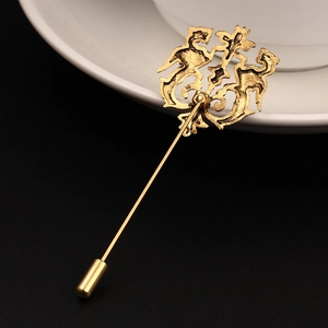 Close-up of vintage gold stick pin featuring ornate hollow relief and protective cap