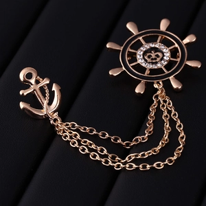 Vintage gold nautical anchor and helm brooch with chains and rhinestones on black background