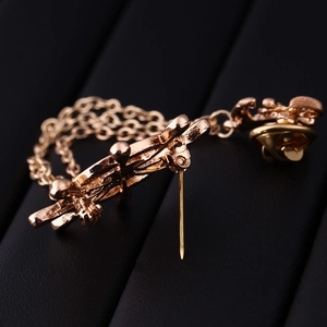 Golden nautical ship wheel brooch with double chain and pin backing on black leather