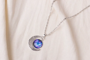 Detailed view of hollow crescent moon pendant with nebula galaxy glass cabochon inlay