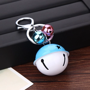 Macro view of blue and white cartoon bell keychain with small colorful metallic bells