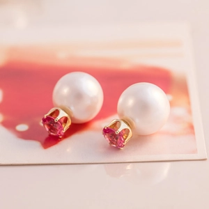 Detailed close-up of double-sided stud earrings with white pearl and pink faceted gemstone
