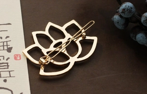Detailed view of a golden lotus metal hair clip with hollowed-out vintage design