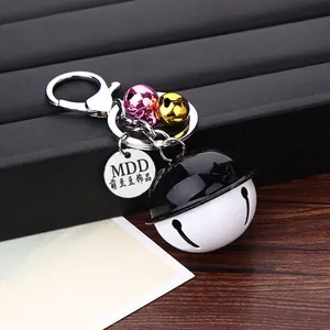 Minimalist black and white bell keychain with metal lobster clasp and small gold accents