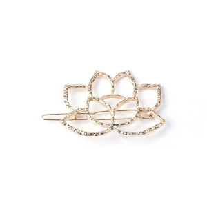 Elegant gold lotus flower hair clip with hammered metal texture on white background
