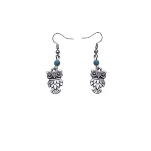 Détail macro de boucles d'oreilles hibou rétro avec perle turquoise et argent vieilli
