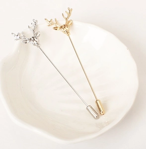 Épingles à revers cerf vintage en or et argent sur une assiette en coquillage