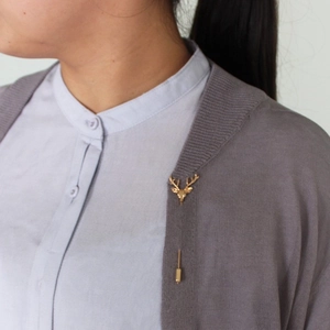 Broche tête de cerf dorée vintage sur un cardigan en maille grise pour hommes