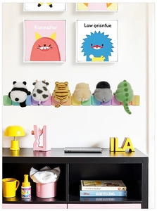 Detail showing the plush textures of cartoon panda, cow, and tiger animal wall cushions