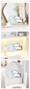 Close-up of cute cartoon dog wall sticker applied to a bathroom mirror and toilet cover