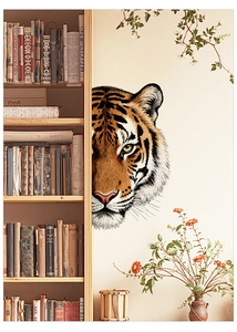 Dettaglio di adesivo murale con tigre che sbircia accanto a una libreria in legno
