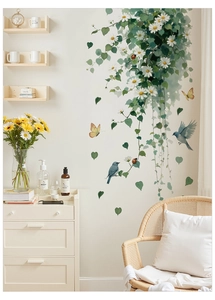 Detail of floral wall decals featuring white daisies green vines and blue birds in home interior