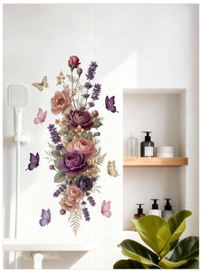 Dettaglio di adesivi murali con fiori rosa e farfalle su piastrelle bianche da bagno