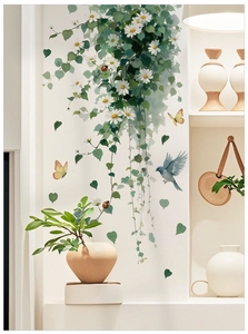 Detail of floral wall decals featuring white daisies green vines and blue bird on white wall