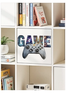 Détail du sticker mural GAME avec manette sur un meuble blanc dans une salle de jeux