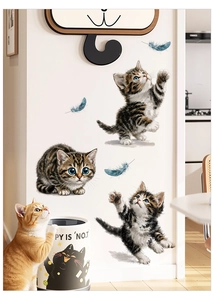 Detail of cute tabby cat wall stickers with blue feathers and a real orange kitten
