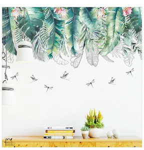 Detail view of tropical green leaves and flying dragonfly wall stickers on a white wall