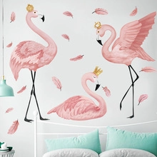 Pink flamingo wall stickers with gold crowns and feathers over a cozy bedroom headboard