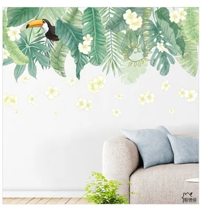 Detail of tropical green leaf wall decals with a toucan and white flowers on a living room wall