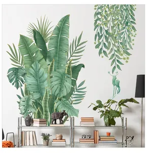 Détail de stickers muraux PVC feuilles tropicales et silhouette de cerf vert sur mur blanc