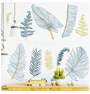 Detail of tropical leaf wall stickers featuring blue and gold foliage with artistic text