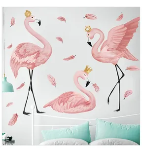 Detailed view of pink flamingo wall stickers with gold crowns and feathers over a bed