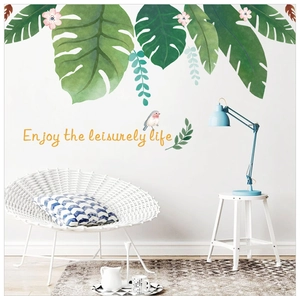 Détail de stickers muraux feuilles tropicales avec lettrage d'art dans une chambre claire