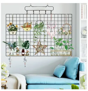 Black iron wall grid set with dream catcher and home decor accessories on white wall