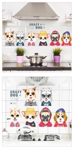 Detail showing cartoon dog wall stickers applied on white kitchen tiles for oil protection