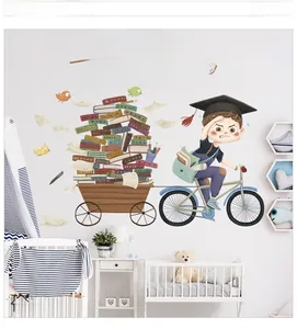 Detail view of cartoon boy on bicycle wall sticker with motivational books illustration